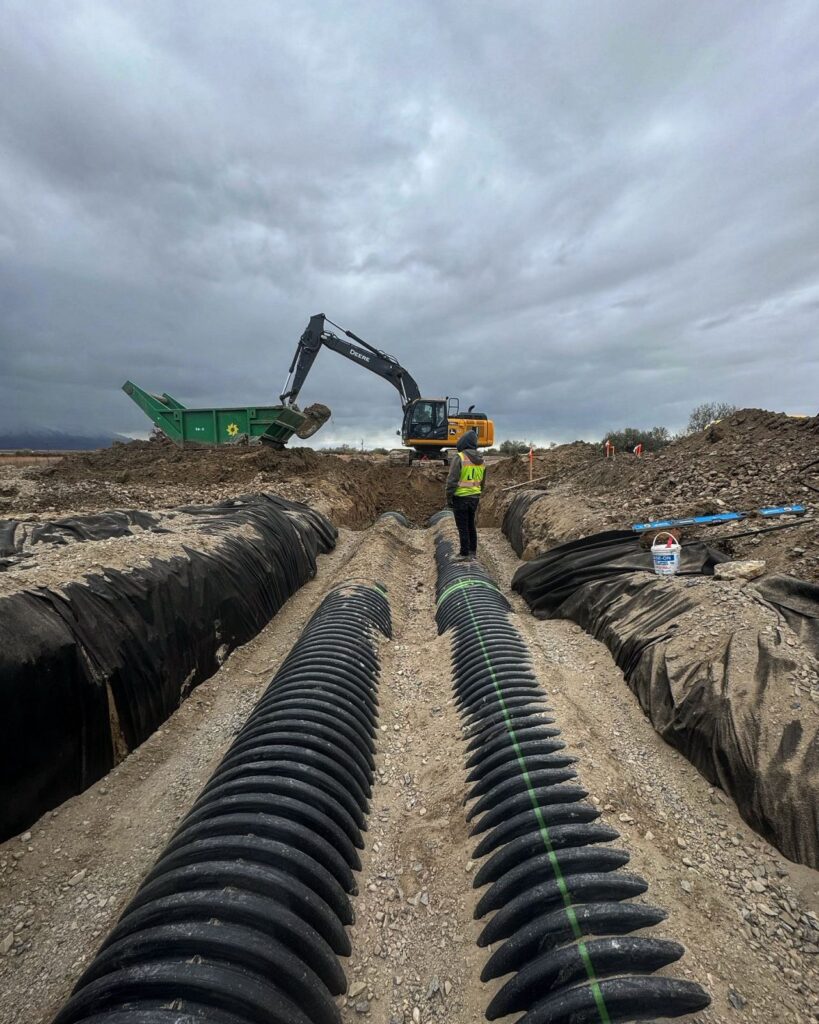 Laying large black pipe on a major construction site in Utah.